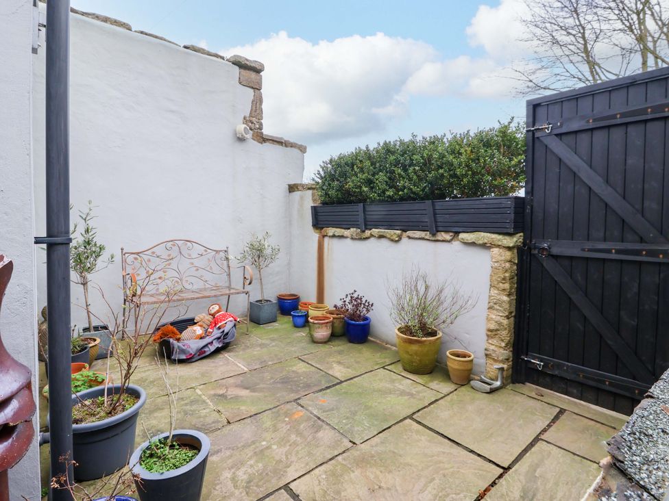 A garden with potted plants and a bench at The Green in Sawley near Ripon