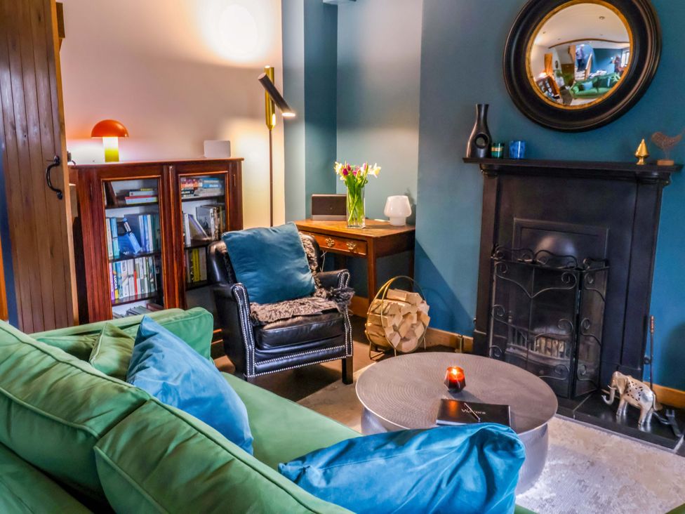A living room with a green sofa and bookshelf at The Green in Sawley near Ripon