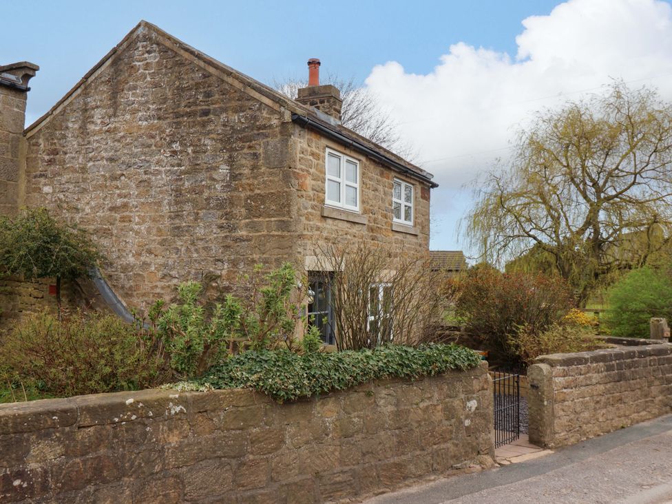 A house with a stone wall and garden at The Green in Sawley near Ripon