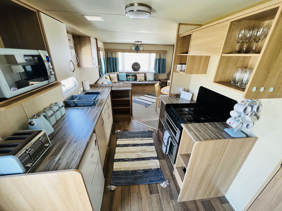 A kitchen with appliances and dining area at The Wild’s Waterside Haven in Cleethorpes