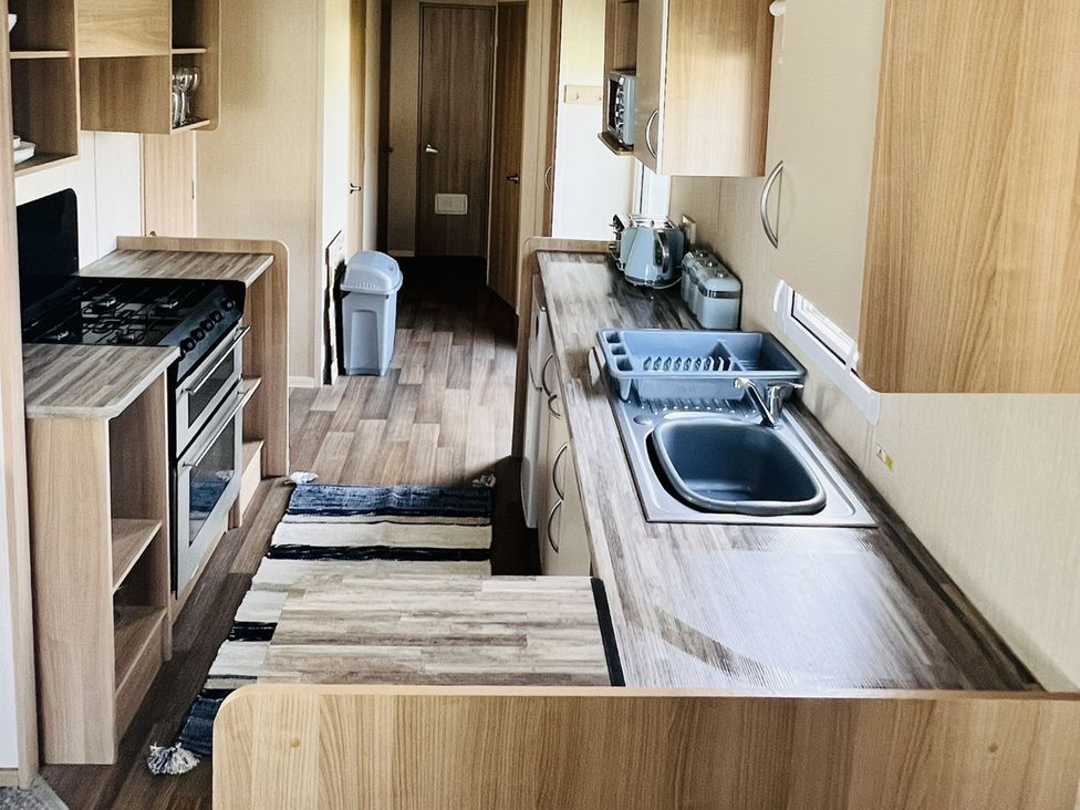 A kitchen with a stove and sink at The Wild's Waterside Haven Cleethorpes