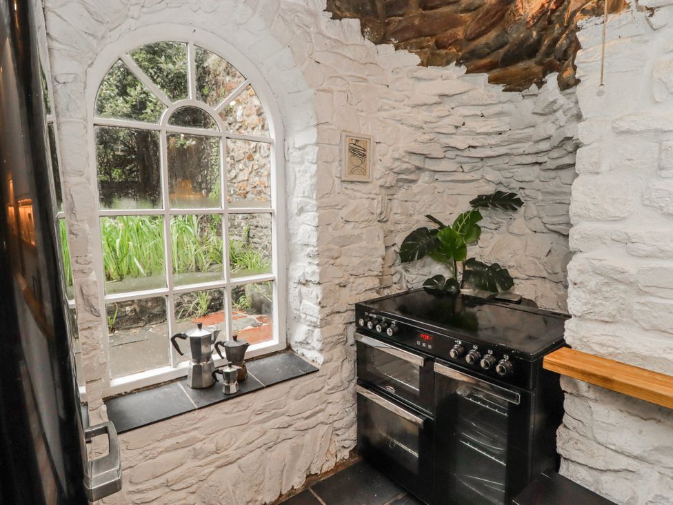 A kitchen with a window, oven and plant at The Secret Garden in Narberth