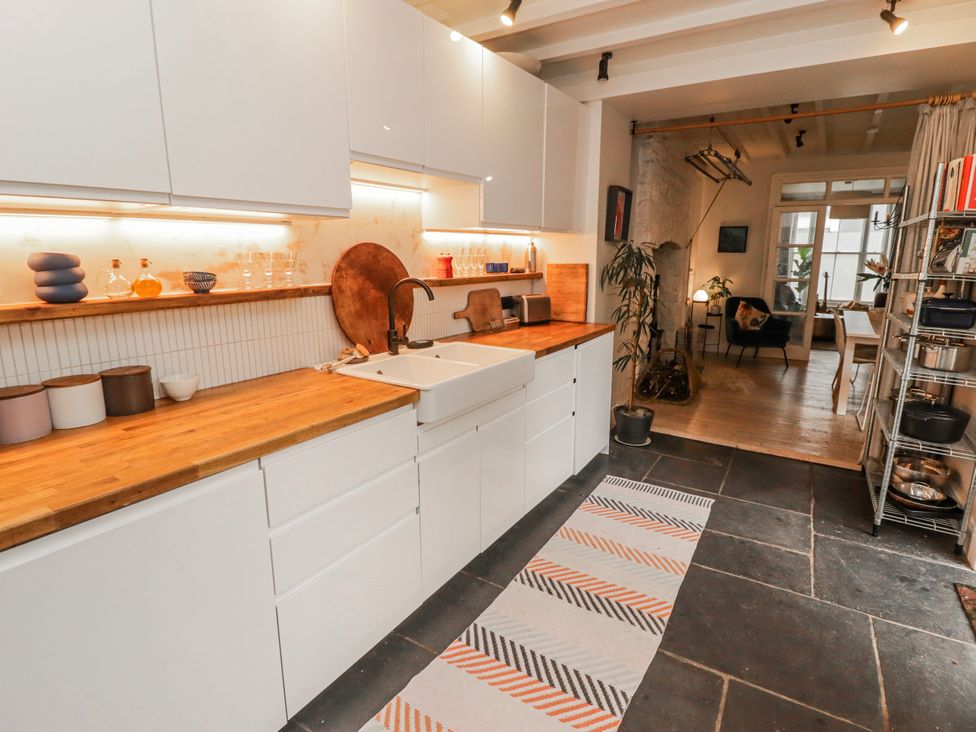 A kitchen with cabinets, sink, and wooden countertop at The Secret Garden in Narberth