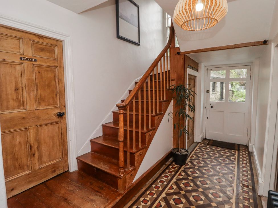 A hallway with a staircase and door at The Secret Garden in Narberth