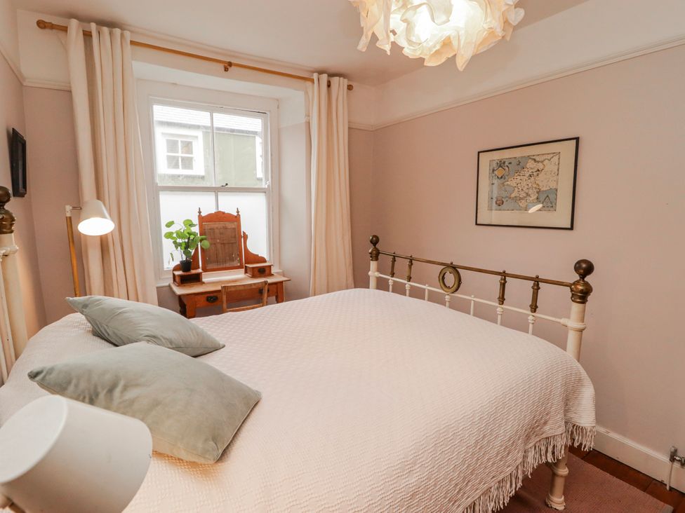 A bedroom with a bed and desk at The Secret Garden in Narberth