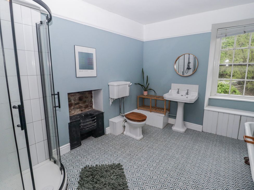 A bathroom with a shower, toilet and sink at The Secret Garden in Narberth