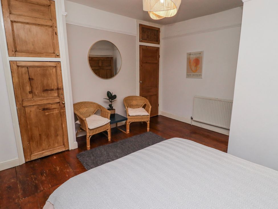 A bedroom with a wardrobe and two chairs at The Secret Garden in Narberth