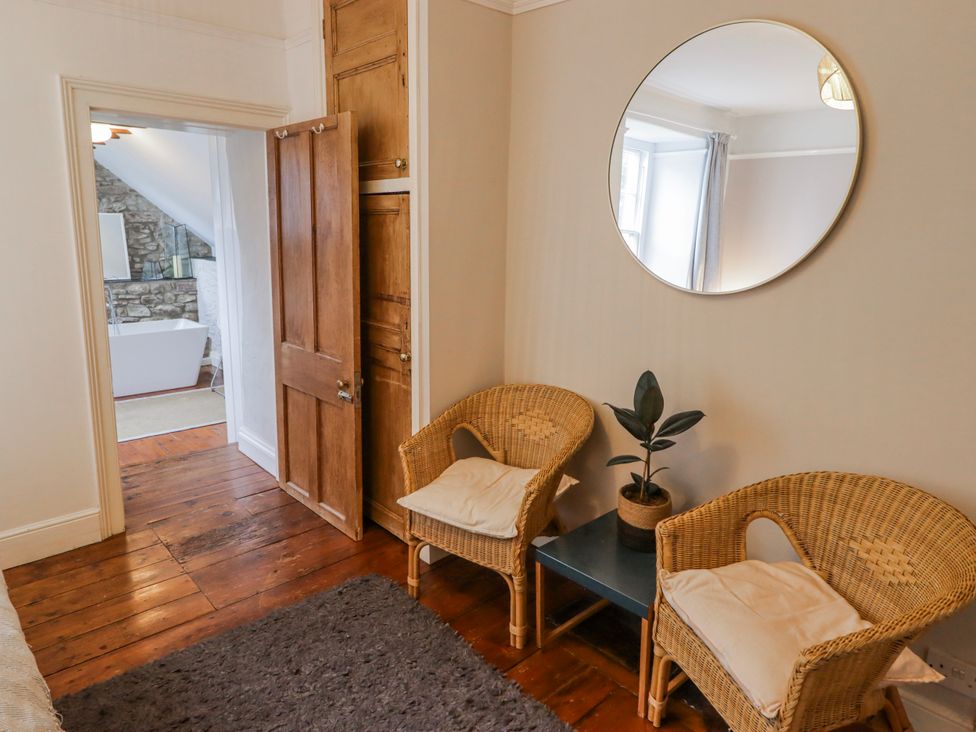 A bathroom with a bathtub and two chairs at The Secret Garden in Narberth