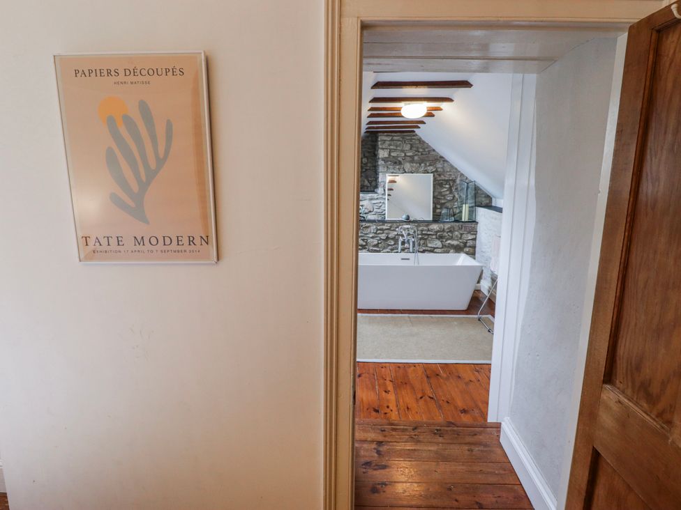 A bathroom with a bathtub and stone walls at The Secret Garden in Narberth