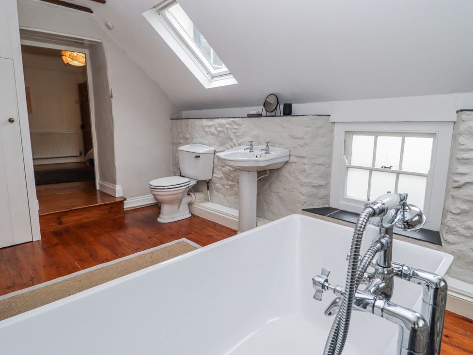 A bathroom with a bathtub, toilet, and sink at The Secret Garden in Narberth