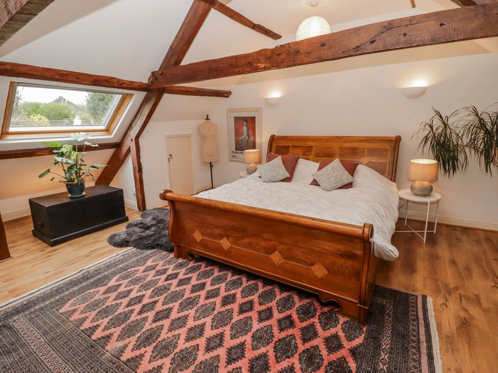 A bedroom with a wooden bed and a plant at The Secret Garden in Narberth