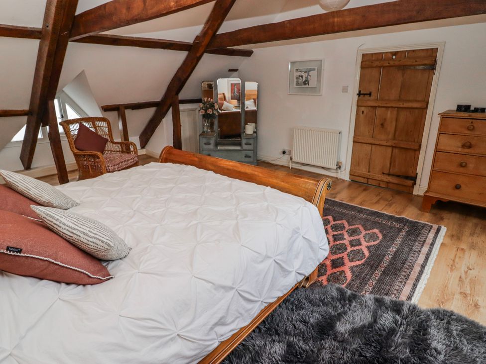 A bedroom with a bed and a chair at The Secret Garden in Narberth