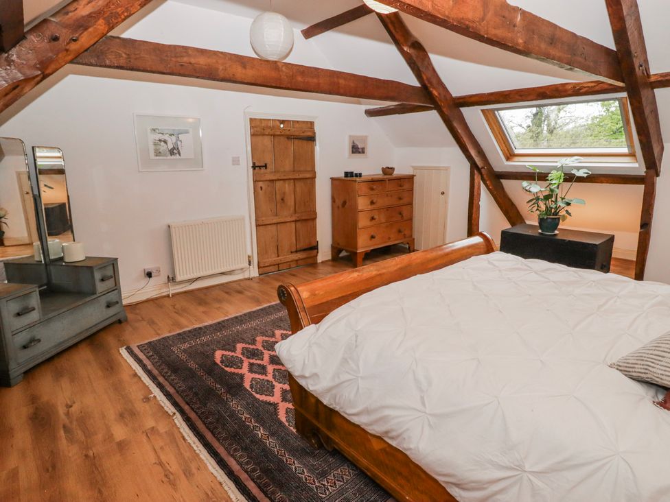 A bedroom with a bed and a chest of drawers at The Secret Garden in Narberth