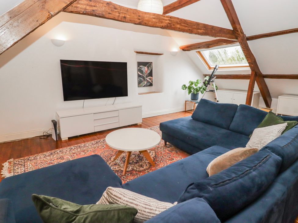 A living room with a television and a sofa at The Secret Garden in Narberth