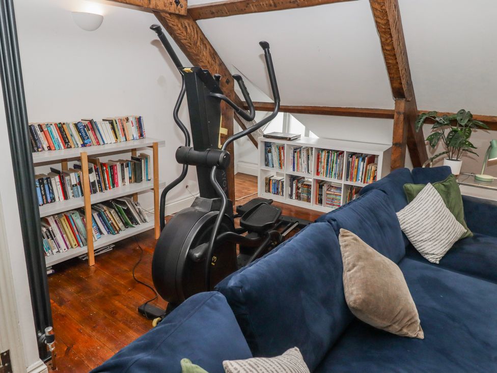 A study with an elliptical machine and bookshelves at The Secret Garden in Narberth