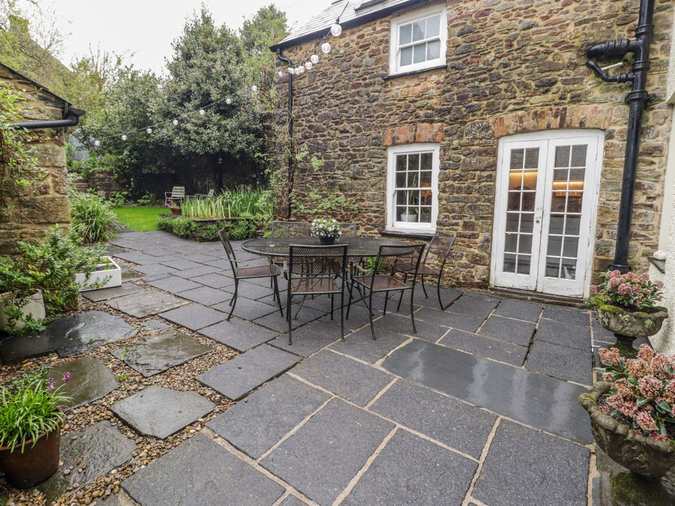 An outdoor space with a stone wall patio and table at The Secret Garden in Narberth