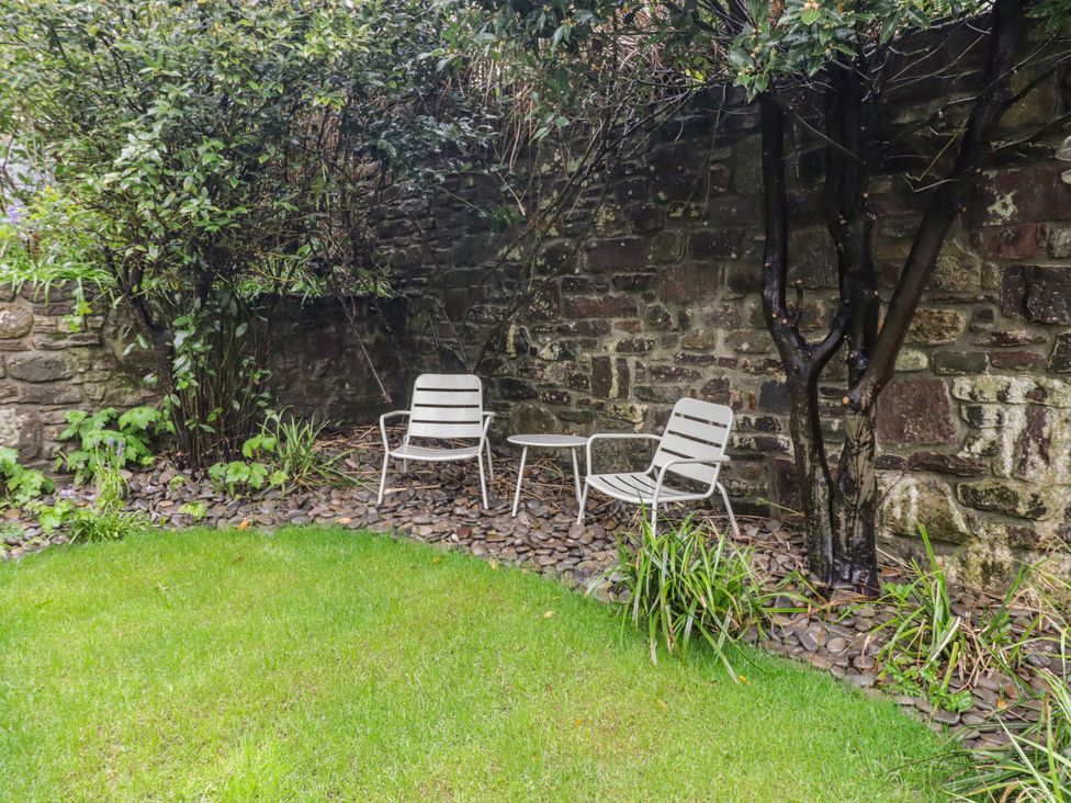 A garden with two chairs and a table at The Secret Garden in Narberth