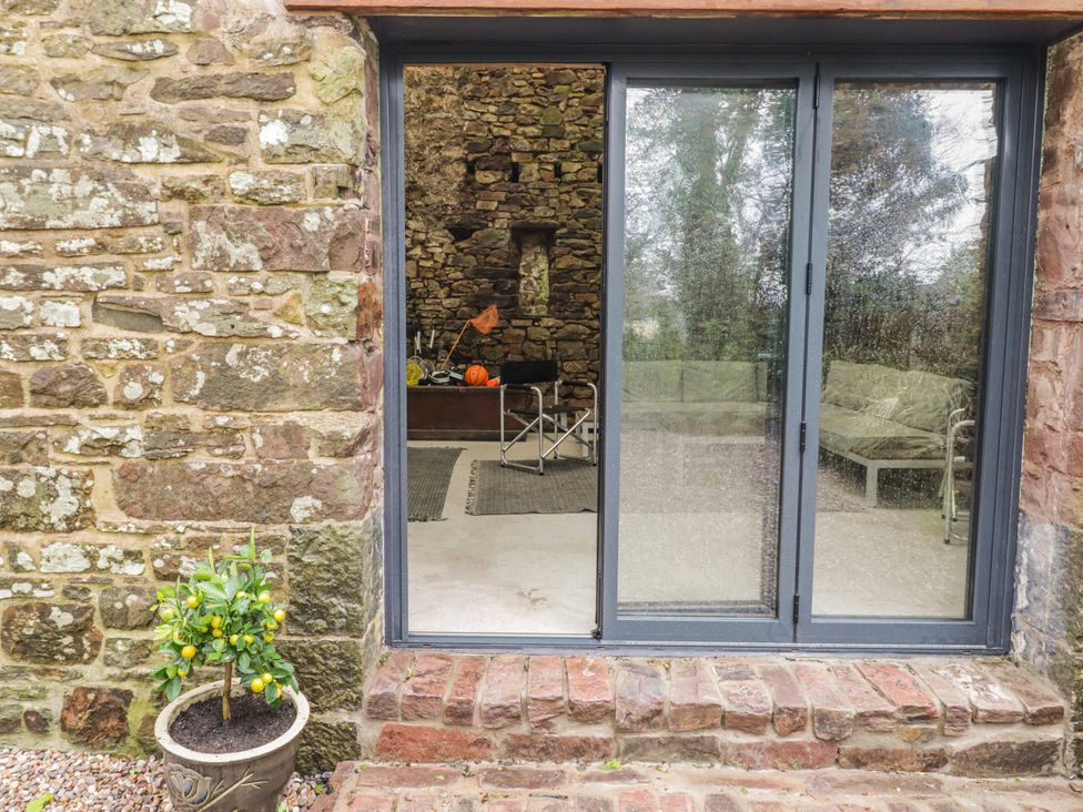 A sliding glass door with a view of a seating area at The Secret Garden in Narberth