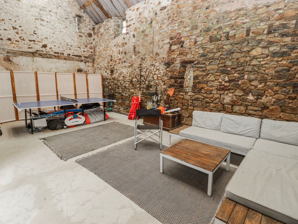 A game room with a ping pong table and sofa at The Secret Garden in Narberth