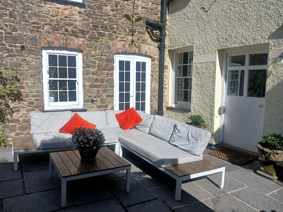 An outdoor patio with seating and a table at The Secret Garden in Narberth