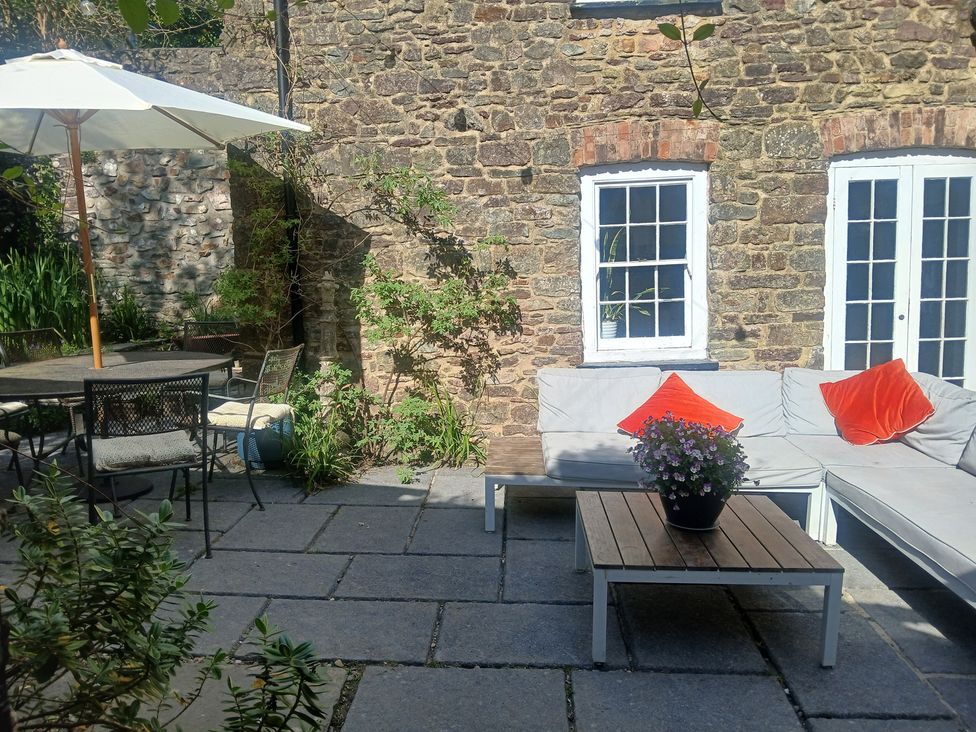 A garden area with a sofa, table, and chairs at The Secret Garden in Narberth