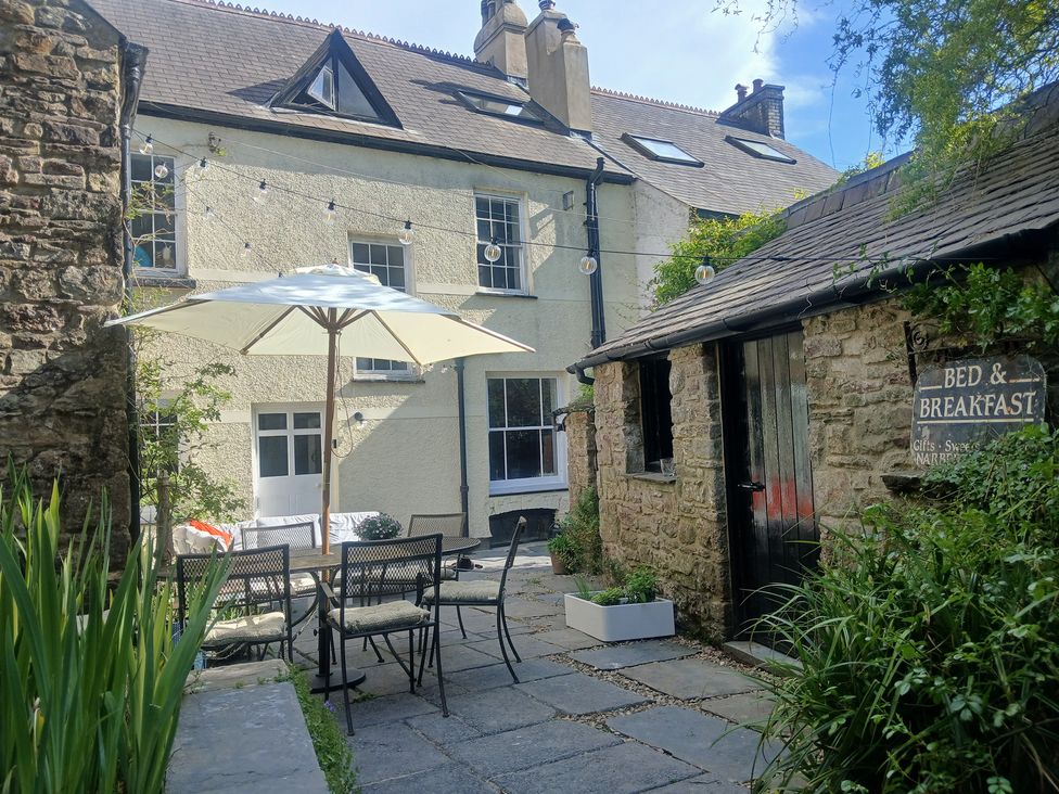 An outdoor area with chairs and table at The Secret Garden in Narberth