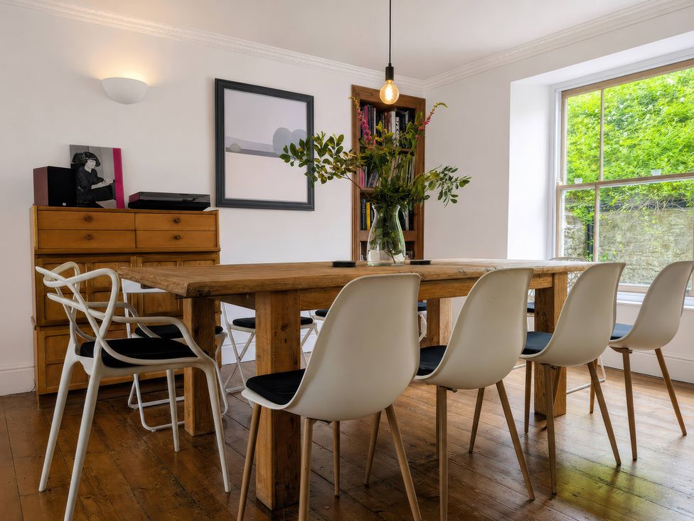 A dining room with a wooden table and chairs at The Secret Garden in Narberth