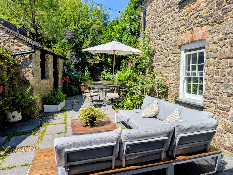 A garden with outdoor furniture and a stone pathway at The Secret Garden in Narberth