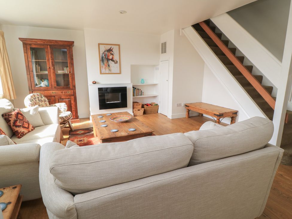 A living room with a sofa, coffee table, and bookshelf at 11 Berry Close in Painswick