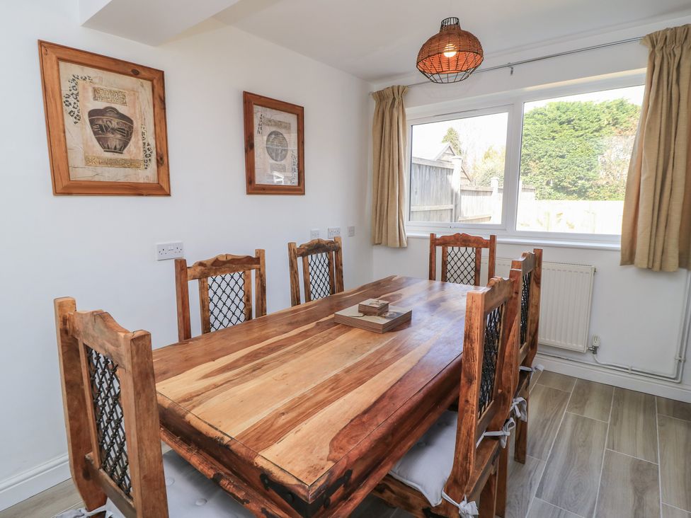 A dining room with a wooden table and chairs at 11 Berry Close in Painswick