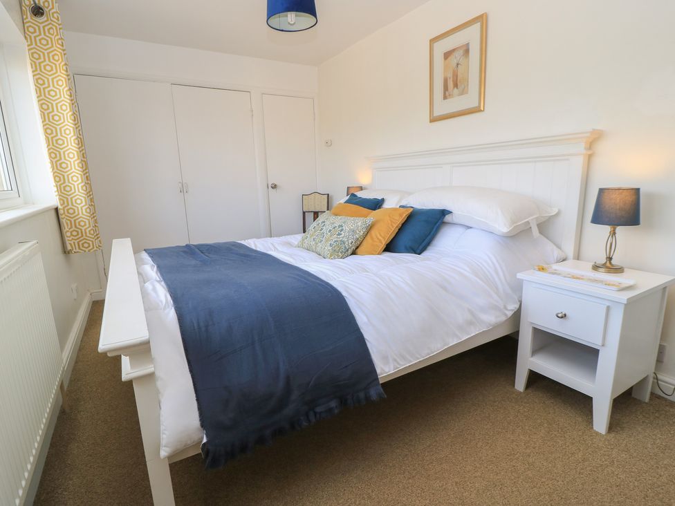 A bedroom with a bed and nightstand at 11 Berry Close Painswick