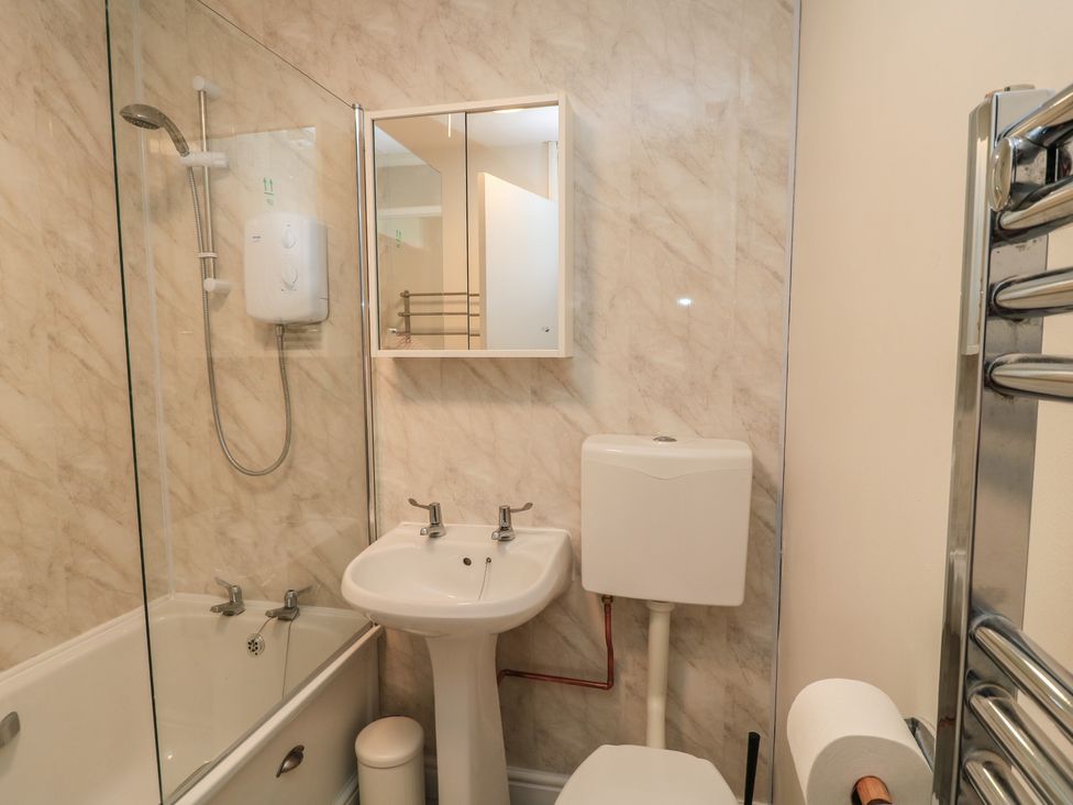 A bathroom with shower, sink, toilet and mirror at 11 Berry Close in Painswick