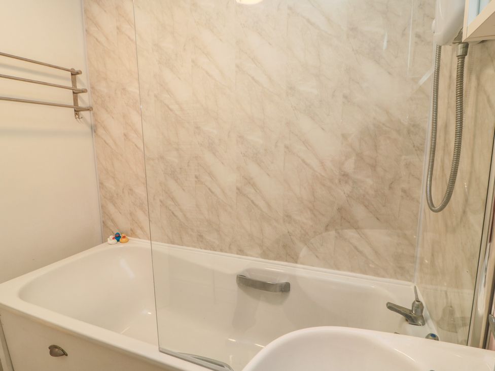 A bathtub with showerhead and rubber duck at 11 Berry Close Painswick