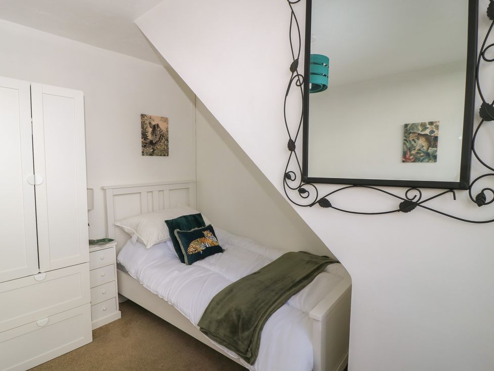 A bedroom with a bed and wardrobe at 11 Berry Close in Painswick