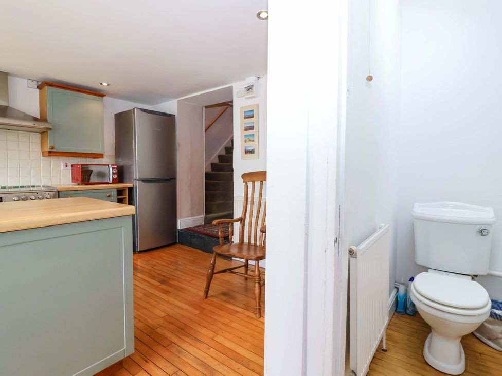 A kitchen with a refrigerator and a toilet near stairs at 12 Heathfield Terrace