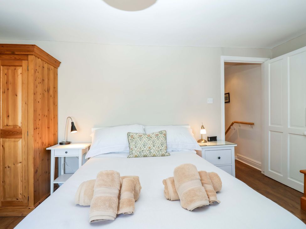 A bedroom with a bed, wardrobe, and nightstand at 12 Heathfield Terrace