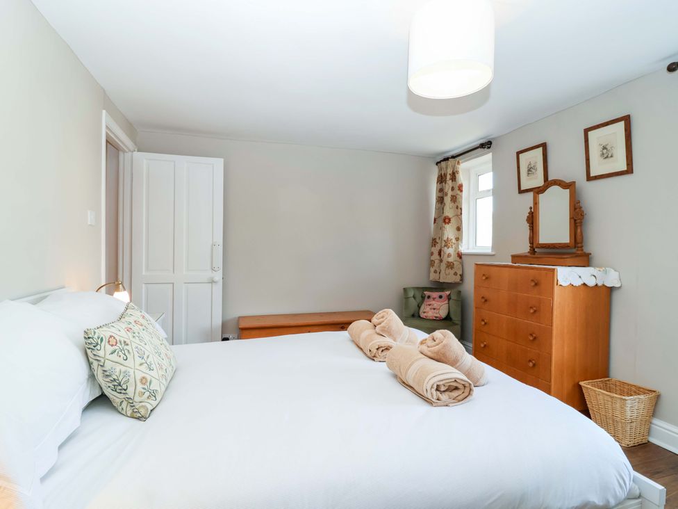 A bedroom with a bed, chair, dresser, and window at 12 Heathfield Terrace