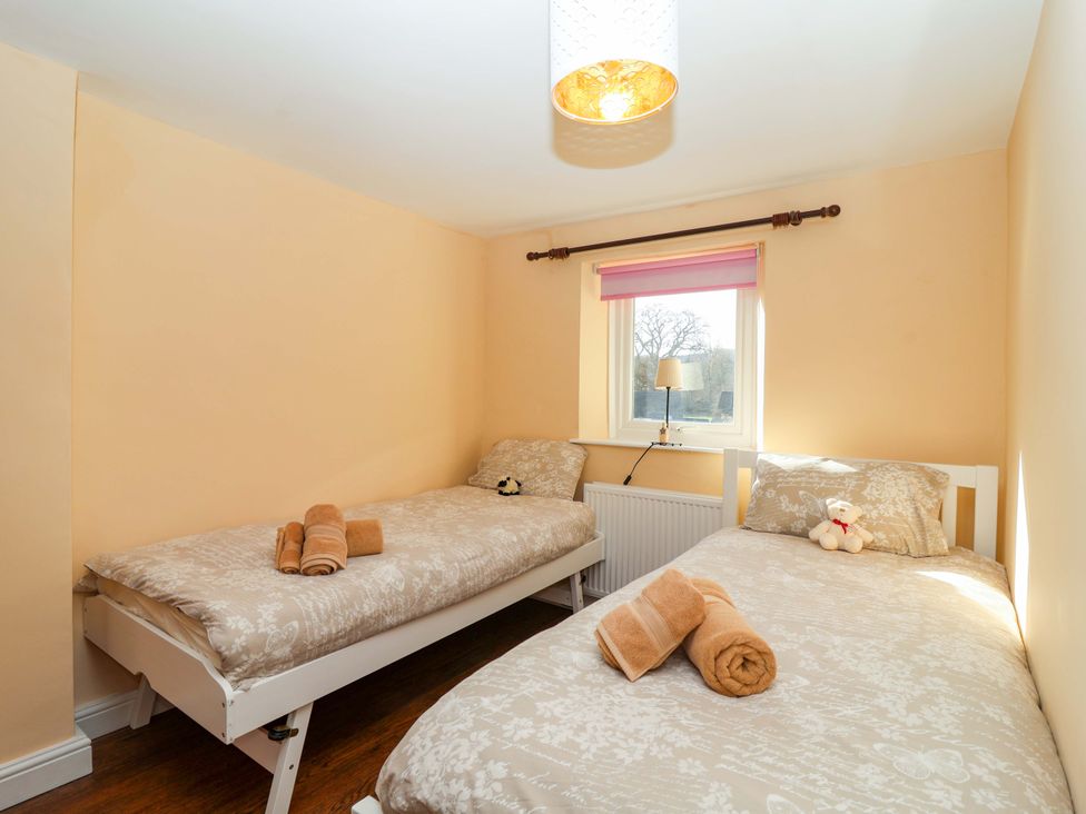 A bedroom with two beds and a lamp at 12 Heathfield Terrace