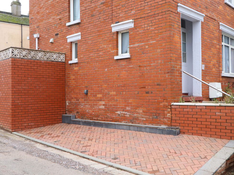 An outdoor area with a brick wall and a door at 16 Elmbank Gardens Paignton