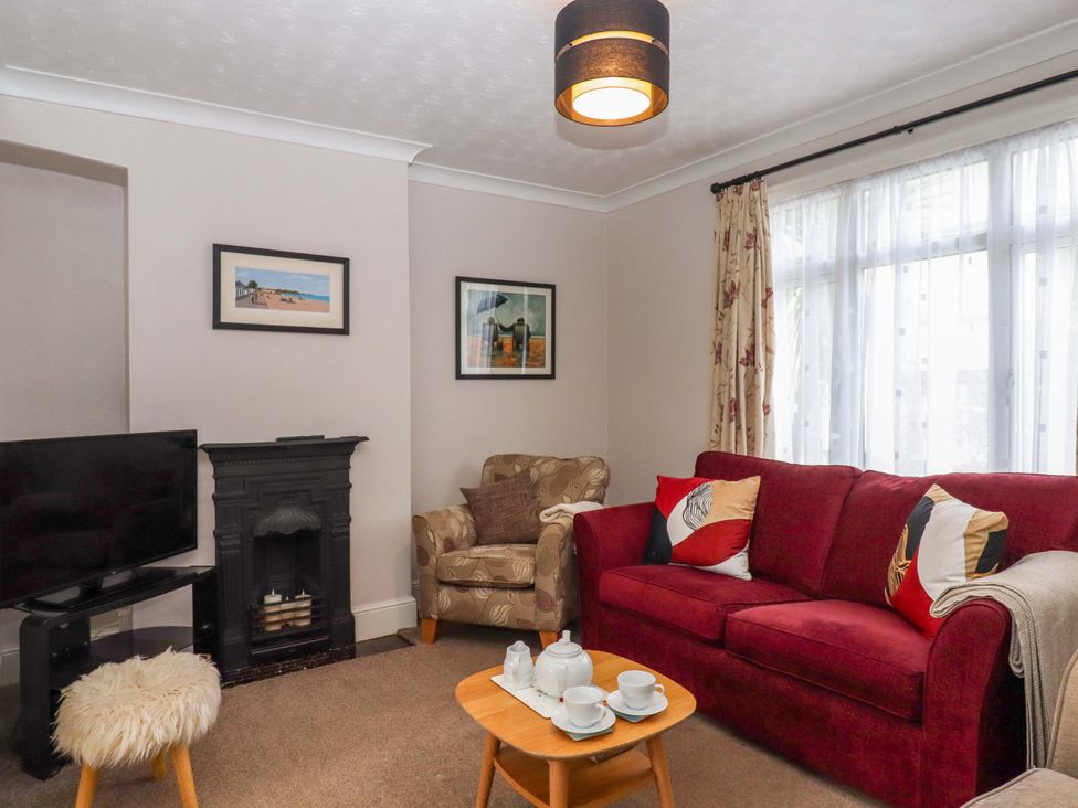 A living room with a television and sofa at 16 Elmbank Gardens in Paignton