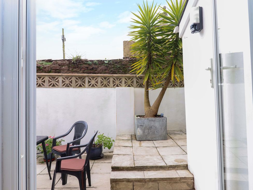 A garden with a table and chairs at 16 Elmbank Gardens in Paignton