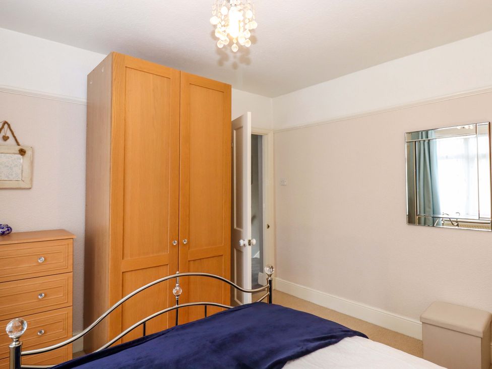 A bedroom with a wardrobe and mirrored wall at 16 Elmbank Gardens in Paignton