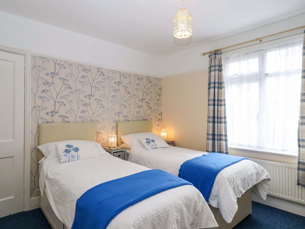 A bedroom with twin beds and a window at 16 Elmbank Gardens Paignton