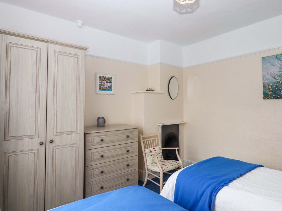 A bedroom with a wardrobe and chest of drawers at 16 Elmbank Gardens, Paignton
