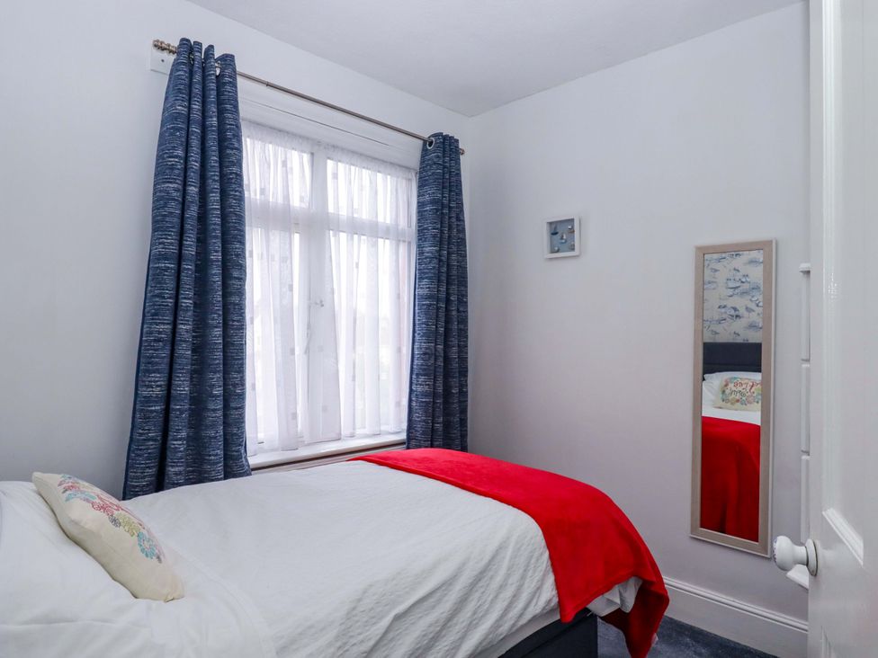 A bedroom with a bed and curtains at 16 Elmbank Gardens in Paignton