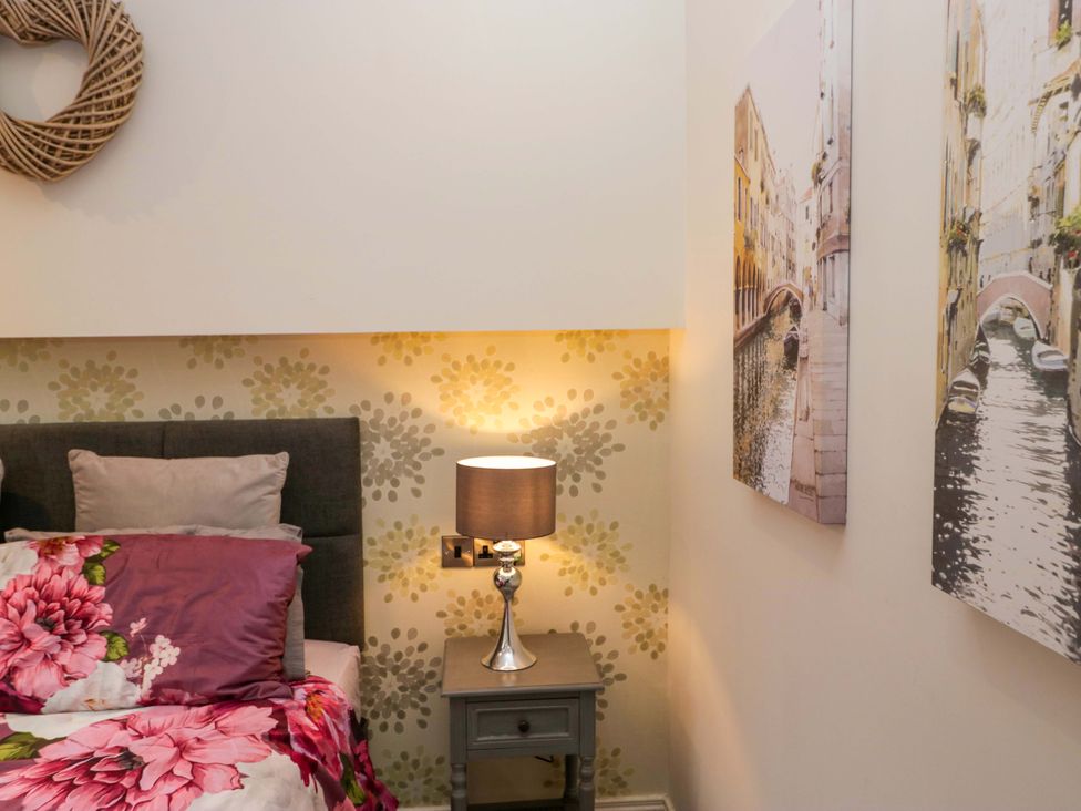 A bedroom with a bed and a lamp at Waters Edge Lodge in Windermere