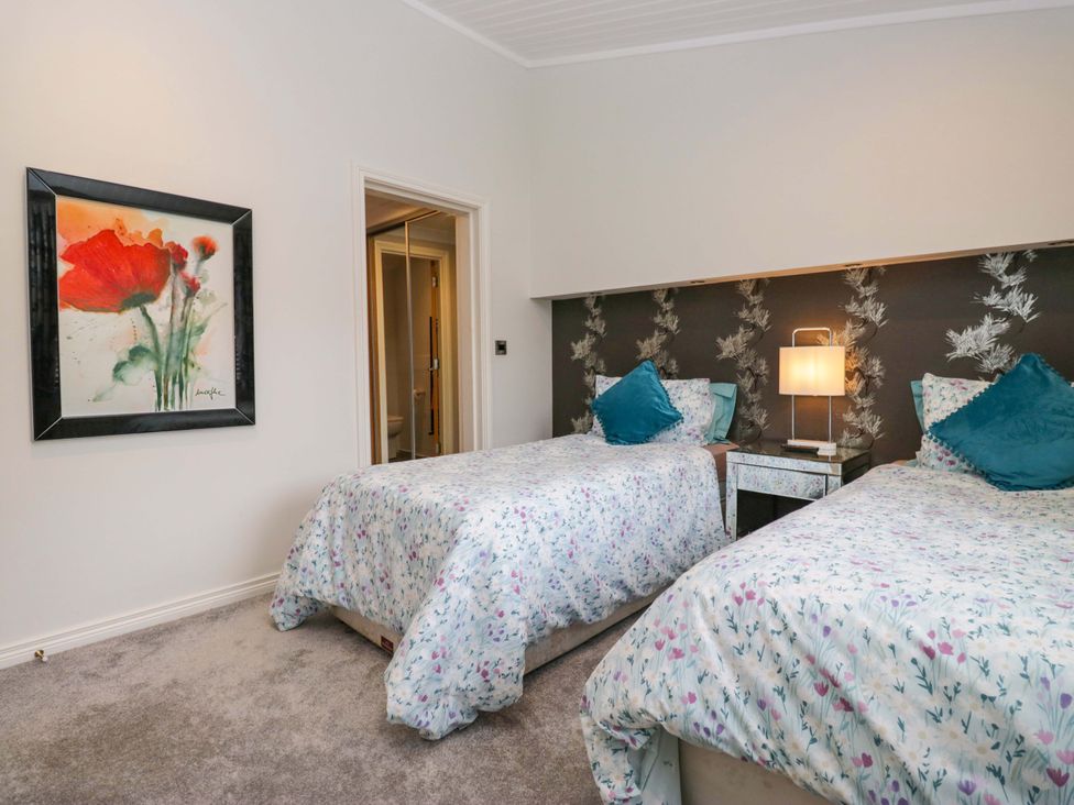 A bedroom with two beds and an artwork at Waters Edge Lodge Windermere