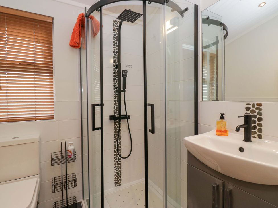 A bathroom with a shower and a sink at Waters Edge Lodge in Windermere