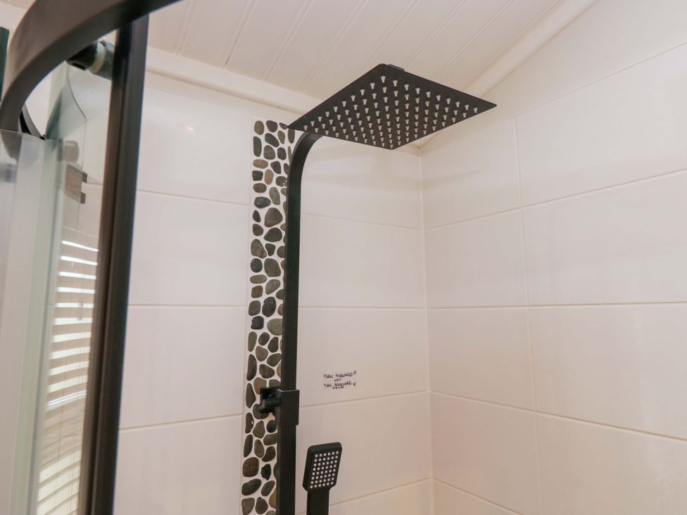 A shower with a large showerhead at Waters Edge Lodge Windermere