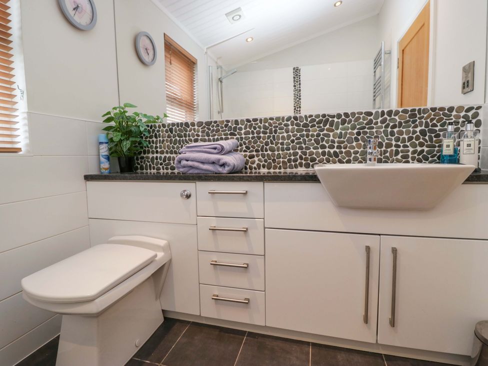A bathroom with a toilet and sink at Waters Edge Lodge in Windermere